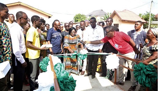 Dr Augustina Naami (with crutches) speaking before the presentation while Andrews Quaye (2nd from left), Headmaster of Taifa Community 3 Basic School, and other officials look on